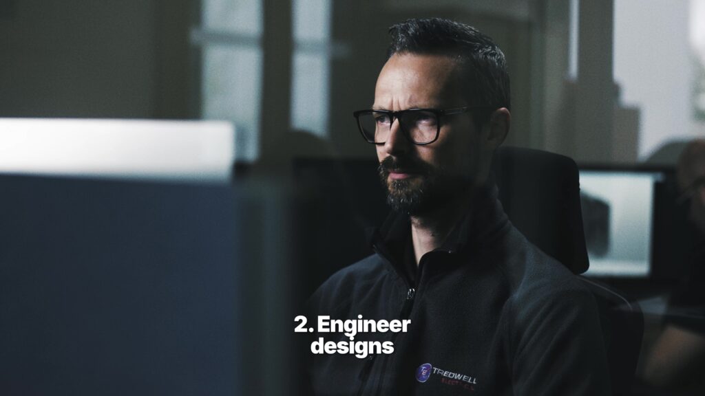 Engineer working at computer on electrical control panel designs
